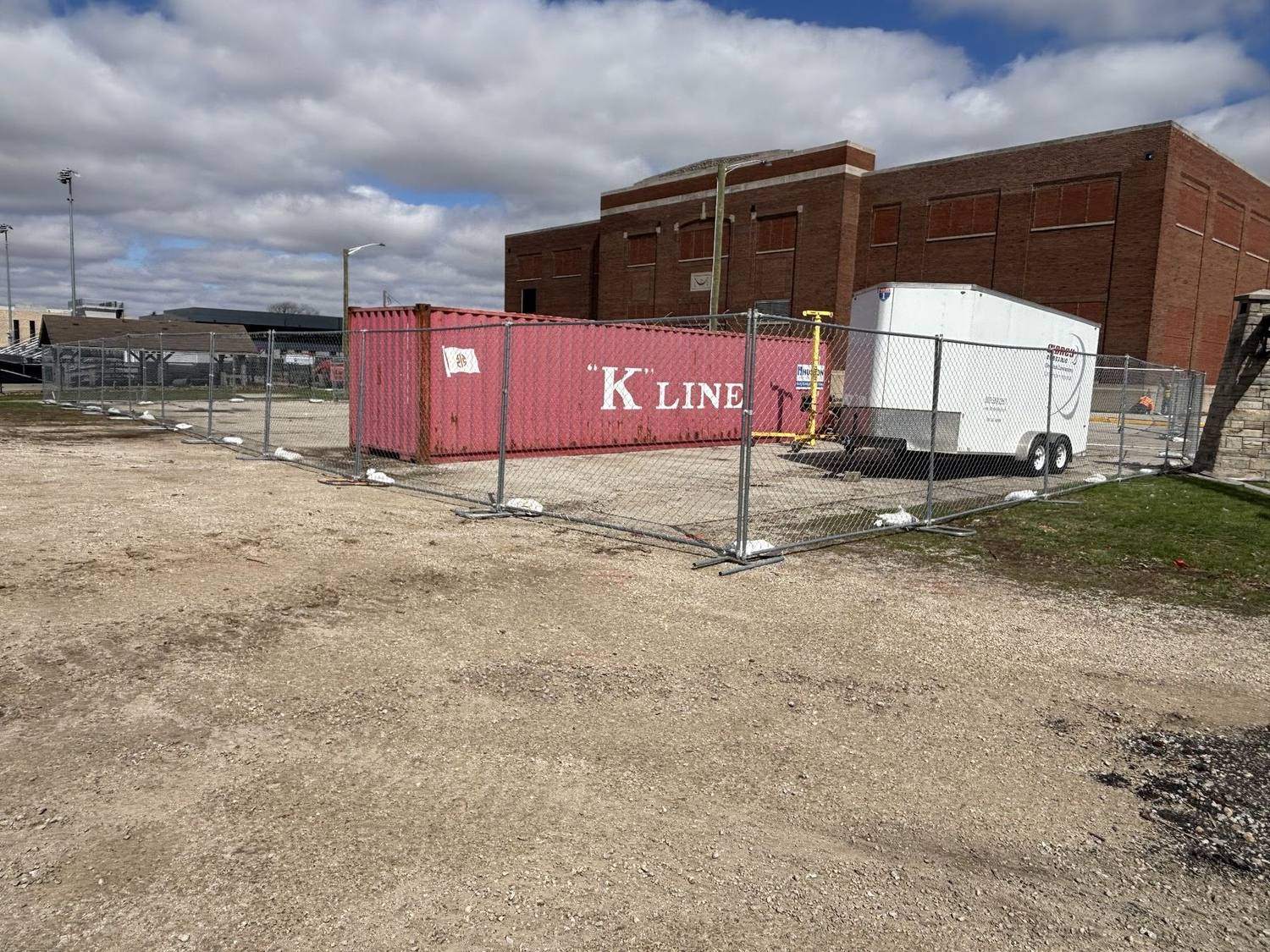 Temporary fencing around a lot with shipping containers stored inside it